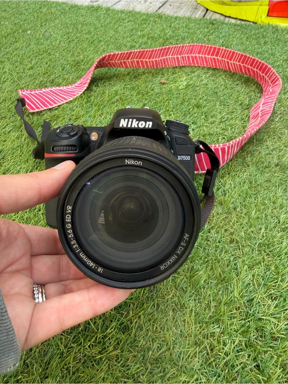 Nikon D7500 DSLR Camera with Black Lens and Red Strap
